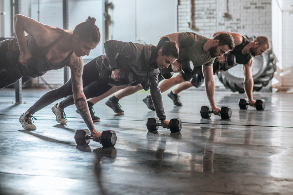 Group,Of,Men,And,Women,Doing,Workouts,Together,At,Gym